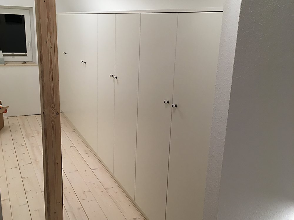 Einbauschrankreihe unter Dachschräge mit altem Holzbalken – Schreinerei Hübl