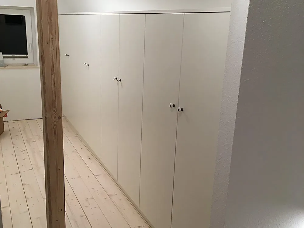 Einbauschrankreihe unter Dachschräge mit altem Holzbalken – Schreinerei Hübl