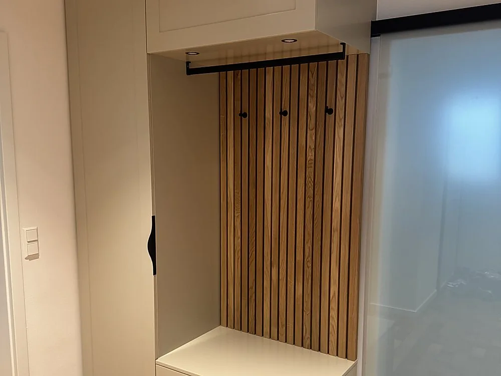 Eichen-Lamellenwand als Rückwand der fertig montierten Garderobe mit Sitzbank