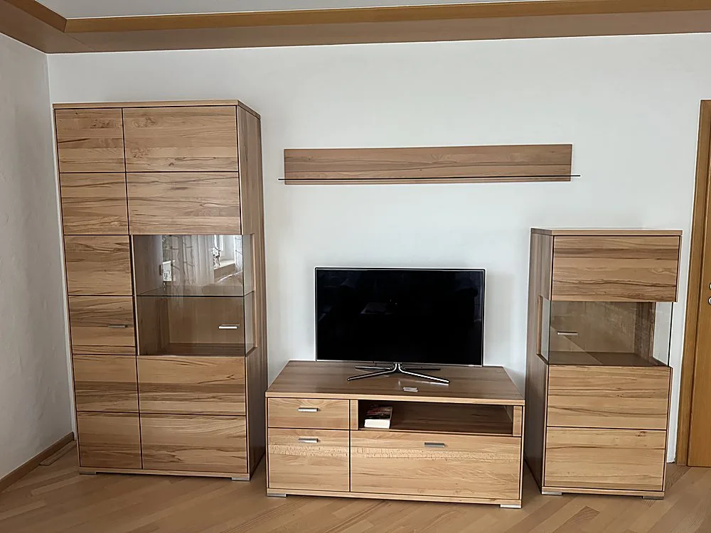 Wohnwand aus Massivholz mit Vitrine, TV-Board und Hängeregal – Medialösung der Schreinerei Hübl