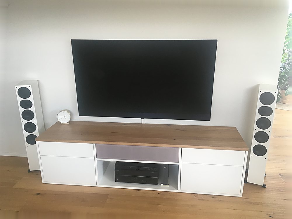 TV-Lowboard in Weiß mit Holzakzent und Standlautsprechern – Medialösung der Schreinerei Hübl