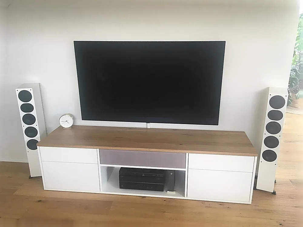 TV-Lowboard in Weiß mit Holzakzent und Standlautsprechern – Medialösung der Schreinerei Hübl