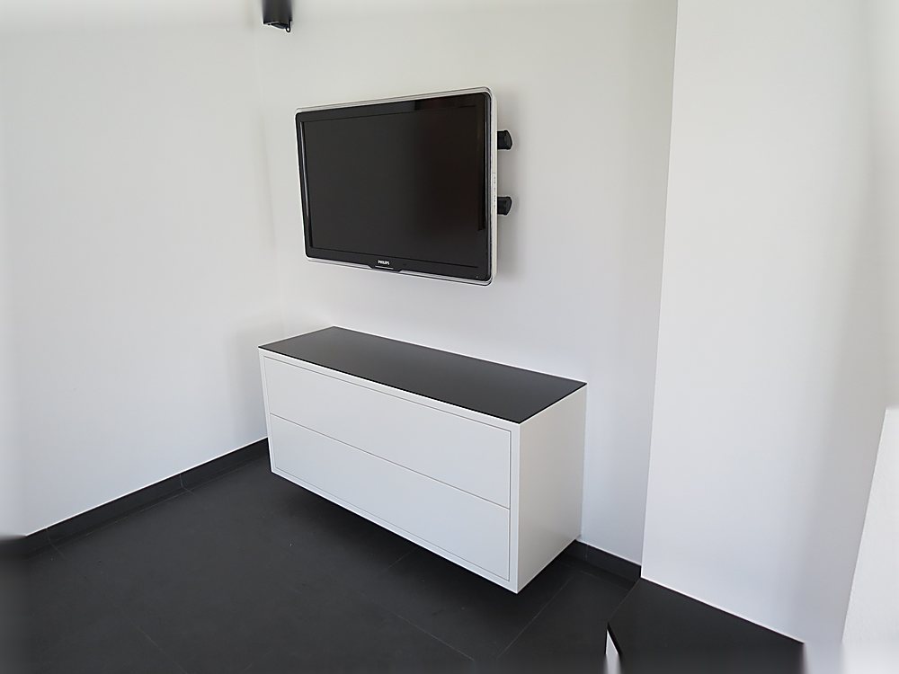 Schmales weißes Sideboard mit wandhängendem Fernseher – Medialösung der Schreinerei Hübl