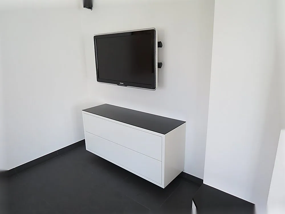 Schmales weißes Sideboard mit wandhängendem Fernseher – Medialösung der Schreinerei Hübl