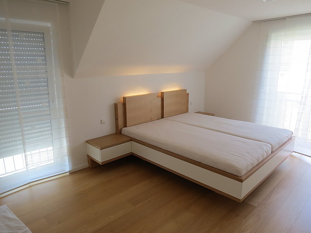 Bett mit Holz-Kopfteil nach Maß im Dachzimmer – Schreinerei Hübl Schorndorf