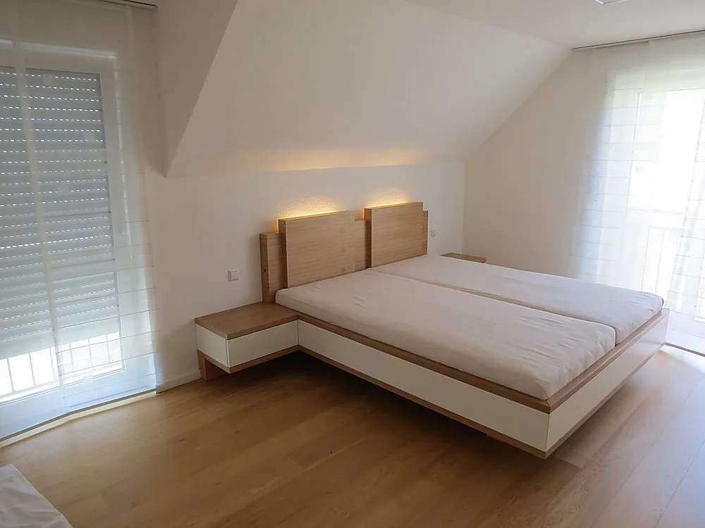 Bett mit Holz-Kopfteil nach Maß im Dachzimmer – Schreinerei Hübl Schorndorf