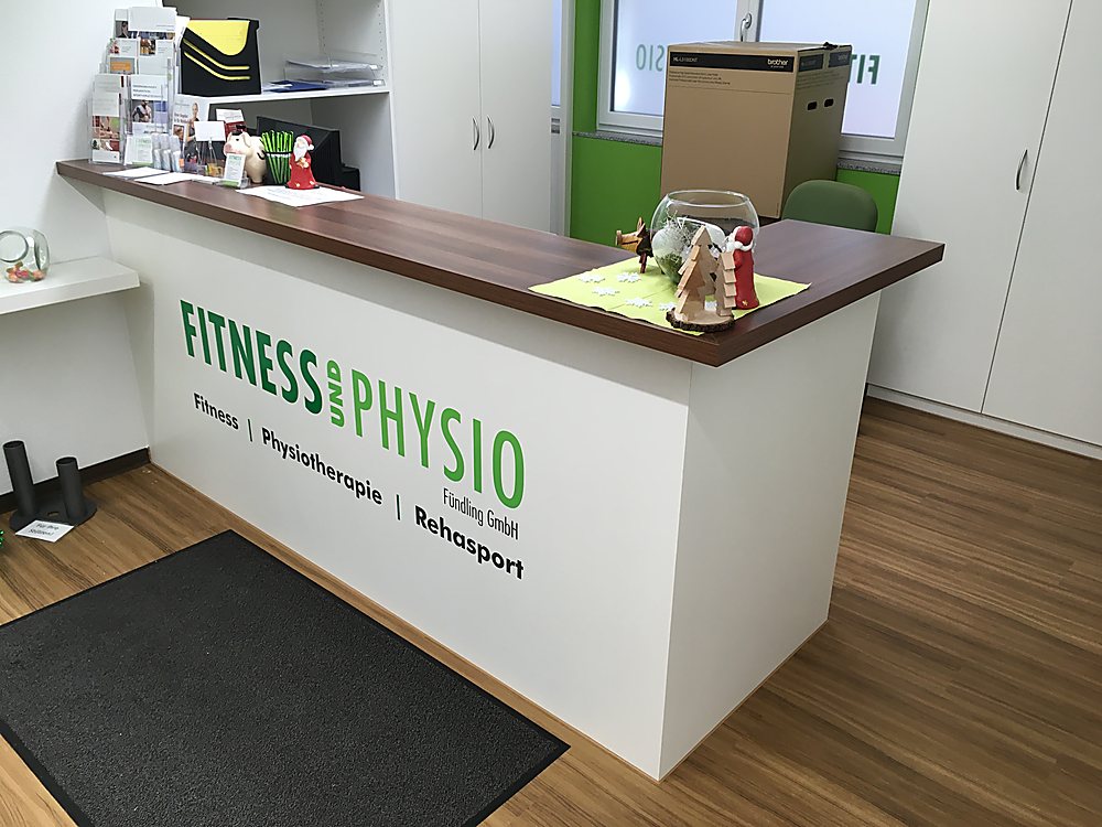 Empfangstresen für ein Fitness- und Physiostudio mit Logo-Wand – Schreinerei Hübl