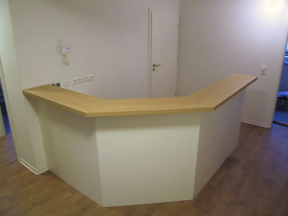 Helle Empfangstheke aus Holz mit cremefarbener Front – Schreinerei Hübl Schorndorf